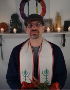 Rev. Dangler holds a bowl of offerings in front of his altar