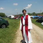 MJD in a red stole and ritual robes in the field at Brushwood