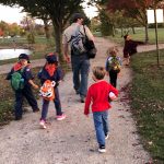 Rev. Dangler leads five masked Tiger scouts through the park