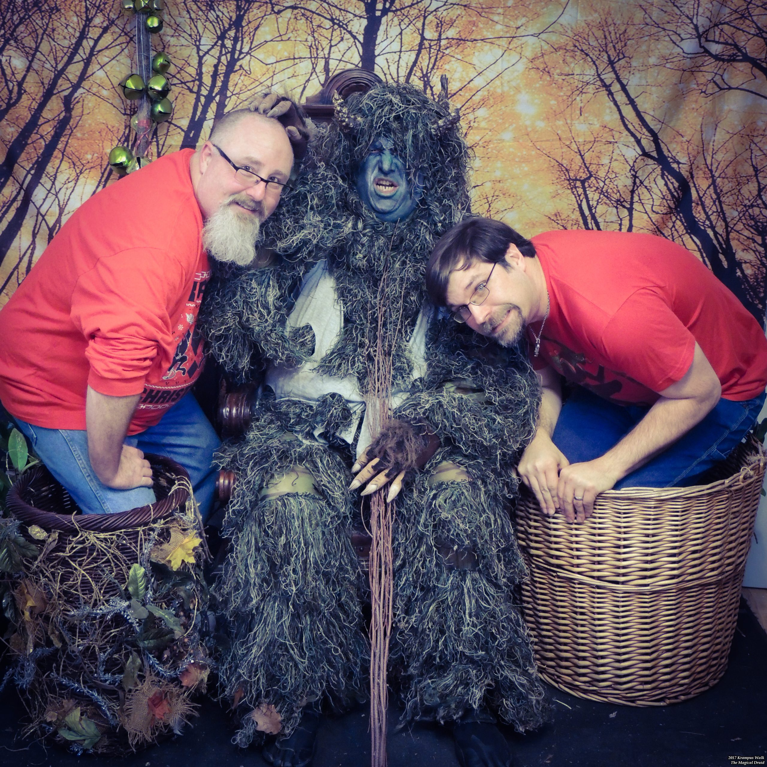 Men cowering in baskets with an angry Krampus between them