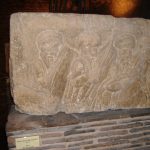 EVRISES is above three older men with hexagonal shields