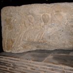 Three figures, two looking out and one in profile, inscription SENANT V