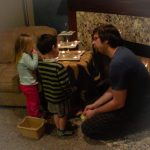MJD and two children sit next to a fire and a three-tiered dish with tealights on it
