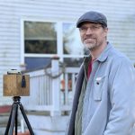 MJD next to a camera that looks like a wooden cube on a tripod