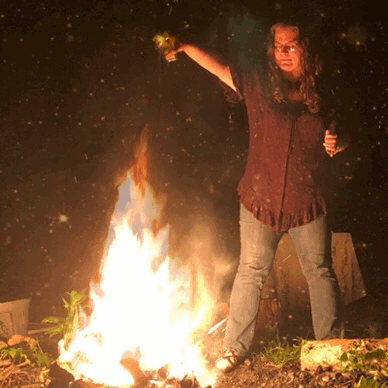 MIssy makes an offering to flame that moves, with embers that appear and dissipate around her.