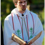 MJD reads from a wooden binder in full ritual regalia
