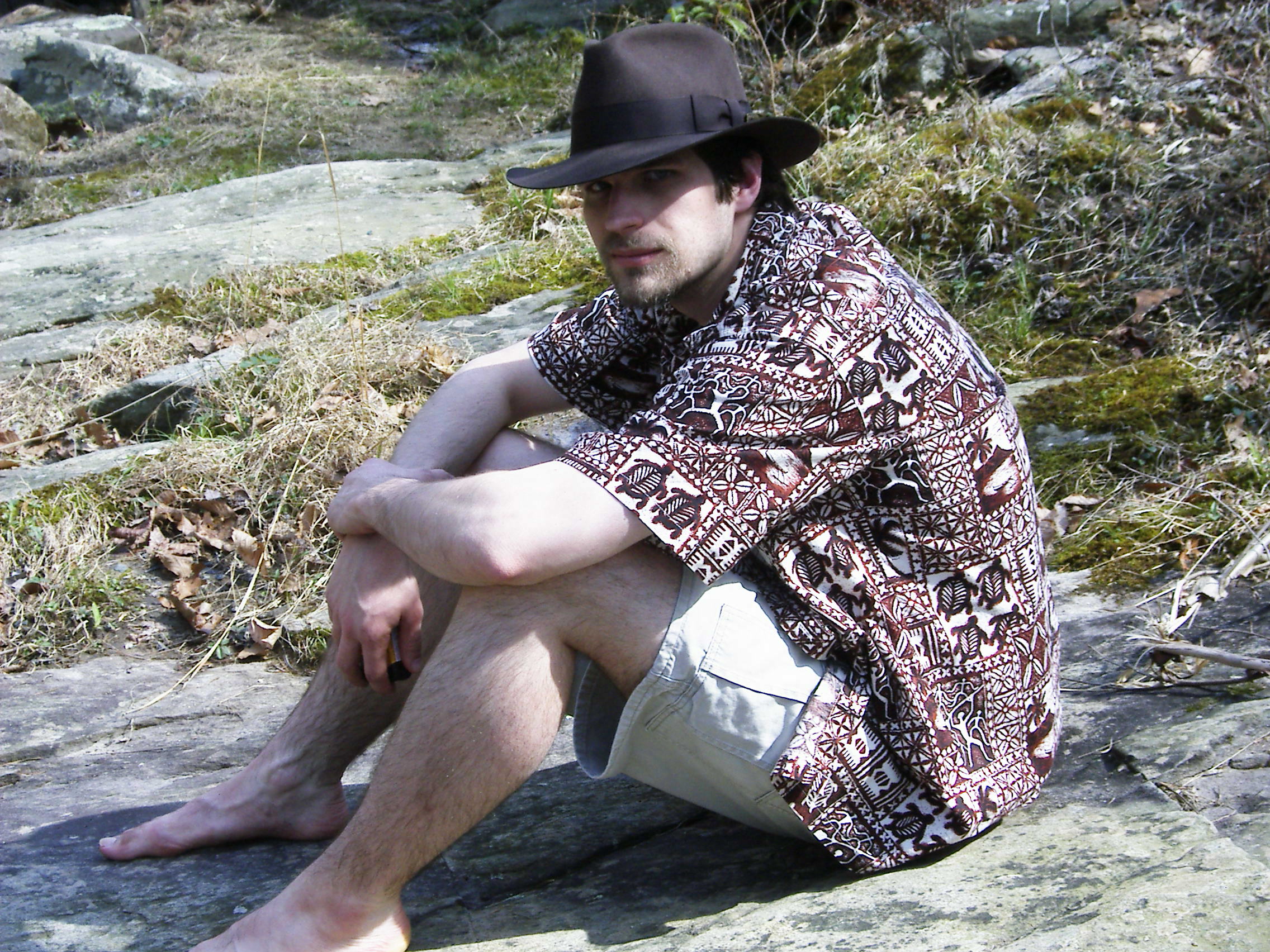 MJD in a Hawaiian shirt sits on the bank of a river