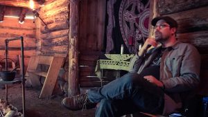 MJD presents a workshop sitting in a cabin, lit by torches